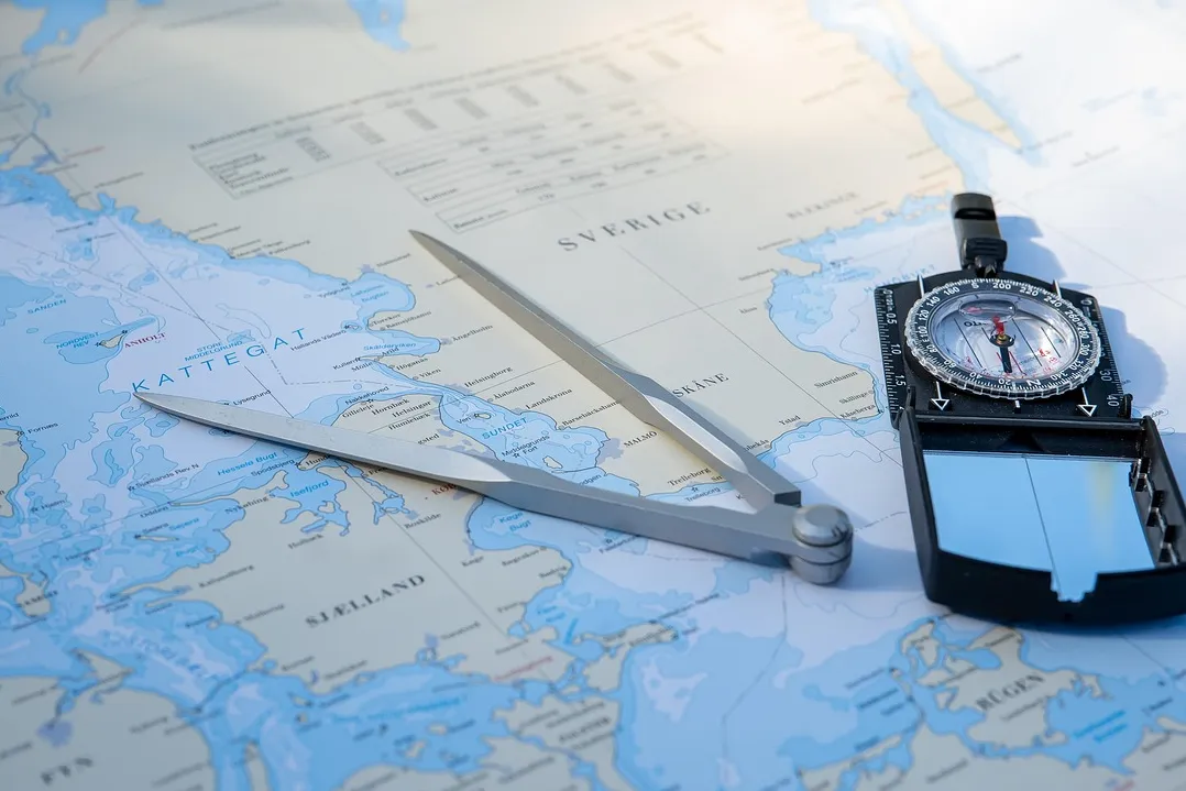 Nautical chart, dividers and compass on a table